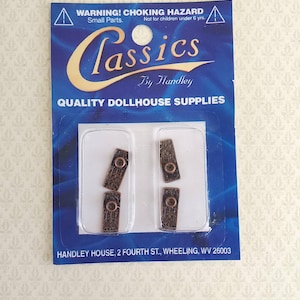 May include: A blue and gold package of dollhouse supplies. The package contains four small, rectangular, bronze-colored pieces with a circular detail. The package reads "Classics by Handley" and "Quality Dollhouse Supplies."