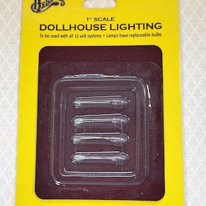 May include: A package of dollhouse lighting bulbs. The yellow and brown packaging reads "DOLLHOUSE LIGHTING" and "1" SCALE". The package contains four small, clear light bulbs. The text "THE GOLD STANDARD IN MINIATURES" is also visible.