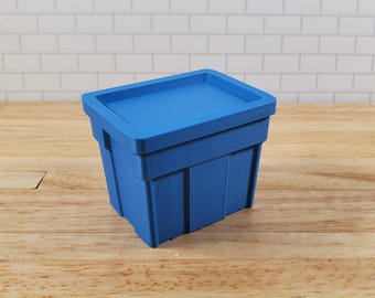 Caja de almacenamiento azul para casa de muñecas con tapa abatible. Modelo a escala 1:12 para dioramas y figuras de acción.