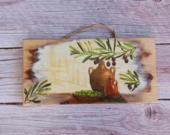 May include: A wooden sign with a painted image of olive branches, two brown ceramic jugs, and a bowl of green olives. The background is a faded image of a city.