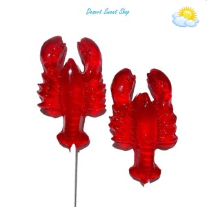 May include: Two red lobster-shaped lollipops on sticks. The lollipops are a bright red color and have a detailed lobster design. The lollipops are perfect for a summer party or a beach-themed event.