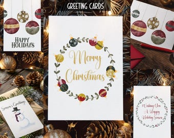 Può includere: Un set di cinque biglietti di auguri natalizi. Un biglietto recita "Happy Holidays" con illustrazioni di ornamenti. Un altro dice "Merry Christmas" in oro circondato da una ghirlanda. Altri biglietti hanno auguri festivi e disegni di ornamenti.