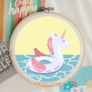 May include: Cross stitch pattern of a unicorn riding an inflatable ring in the water. The pattern is on an 8 inch hoop and uses 18 count Aida cloth. The pattern is designed by variditta.