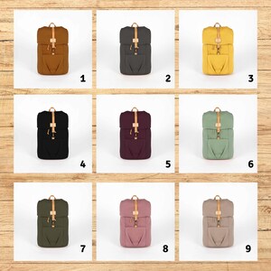 May include: Nine different colored canvas backpacks with leather straps and buckles. The backpacks are arranged in a 3x3 grid.