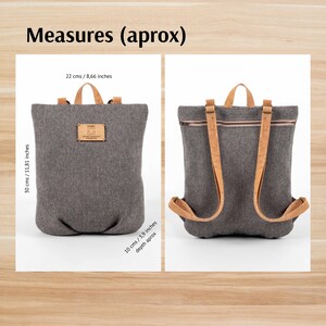 May include: A grey canvas backpack with brown leather straps and a zip closure. The backpack measures 30 cm tall, 22 cm wide, and 10 cm deep.
