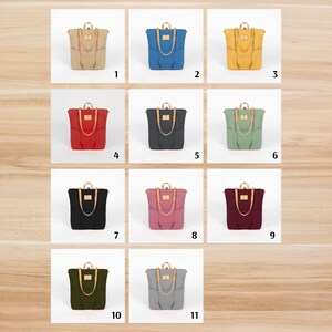 May include: Eleven different canvas tote bags with leather handles and a flap closure. The bags are in various colors, including beige, blue, yellow, red, black, green, pink, burgundy, olive green, and gray.