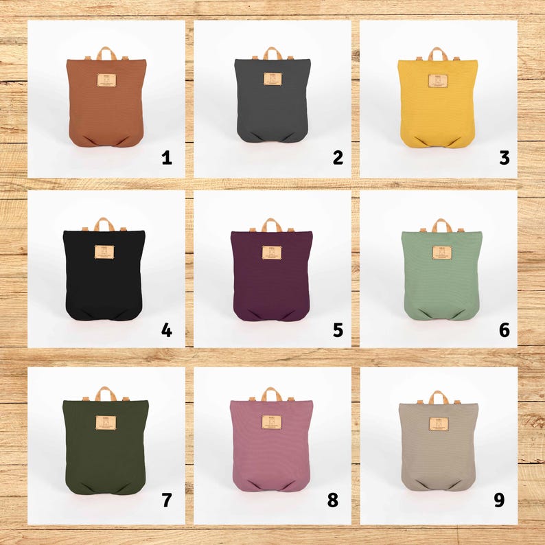 May include: Nine different coloured canvas backpacks with leather straps and a small leather patch on the front. The backpacks are arranged in a 3x3 grid.