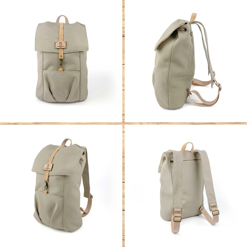 May include: A beige canvas backpack with brown leather straps and buckles. The backpack has a flap closure and a front pocket.