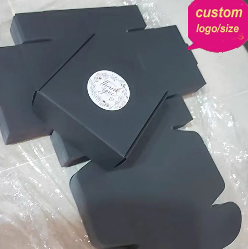 May include: Black cardboard gift boxes with a "Thank You" sticker. The boxes are folded flat and ready to be assembled. The image includes the text "custom logo/size".