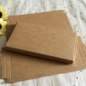May include: Two brown cardboard boxes, one nested inside the other. The larger box has a flap on the side. The smaller box is slightly smaller than the larger box.