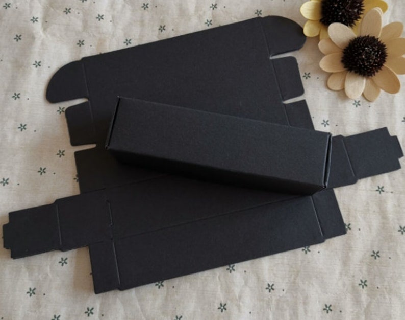 May include: Black cardboard box with a separate inner box. The box is folded flat and ready to be assembled.