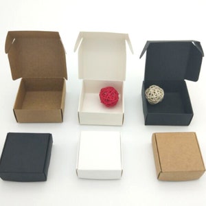 May include: Six small cardboard boxes, three open and three closed. The open boxes are brown, white, and black. The closed boxes are brown, white, and black. The boxes are all the same size and shape.