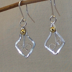 Arrowhead shaped sterling silver earrings with golden bronze bead at the top