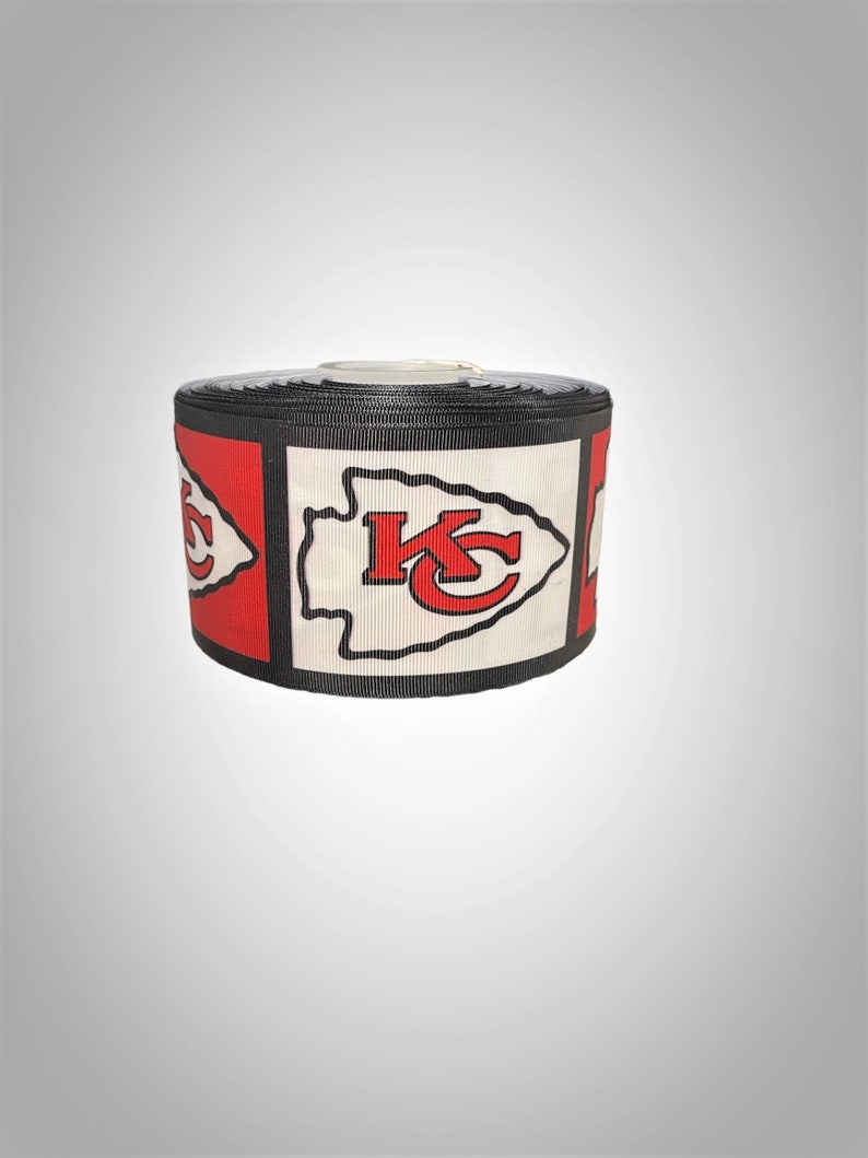 May include: A roll of black and white ribbon with a red and white Kansas City Chiefs logo printed on it.
