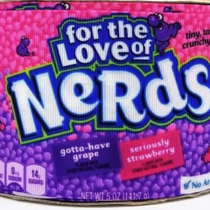 May include: A pink and purple Nerds candy ribbon with the text "for the Love of Nerds" and "tiny, tangy crunchy candy". The ribbon also has the text "gotta-have grape" and "seriously strawberry" with nutritional information.