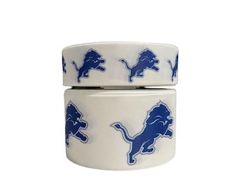 May include: Two rolls of white ribbon with a blue Detroit Lions logo printed on them.