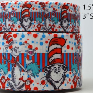 May include: Two rolls of white ribbon with a red and blue striped pattern. The ribbon features a repeating pattern of the Cat in the Hat character from the Dr. Seuss book. The ribbon is available in 1.5" and 3" sizes.