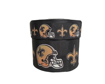 May include: Black and gold ribbon with a repeating pattern of football helmets and fleur-de-lis.