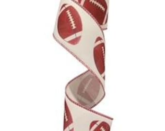 May include: A roll of cream-colored ribbon with a repeating pattern of red footballs. The ribbon has a wired edge with a red stitched border. The footballs are detailed with white laces.