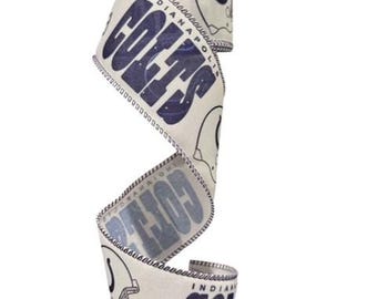 May include: Cream-colored ribbon with navy blue text and accents. The ribbon features the word "COLTS" in large letters, the team's logo, and the city name "INDIANAPOLIS". The edges are finished with a dark blue stitched border.