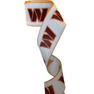 May include: White ribbon with a brown "W" logo repeated along the length. The ribbon has a gold trim.