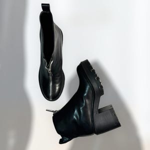 May include: A pair of black leather ankle boots with a zipper up the front and a chunky heel.