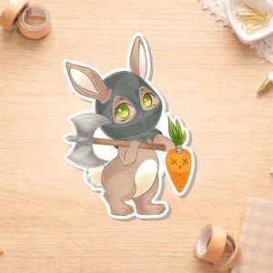 May include: A sticker of a cartoon bunny wearing a black executioner's hood and holding a silver axe. The bunny also holds a carrot with an X-shaped mouth. The bunny is brown and white with green eyes.