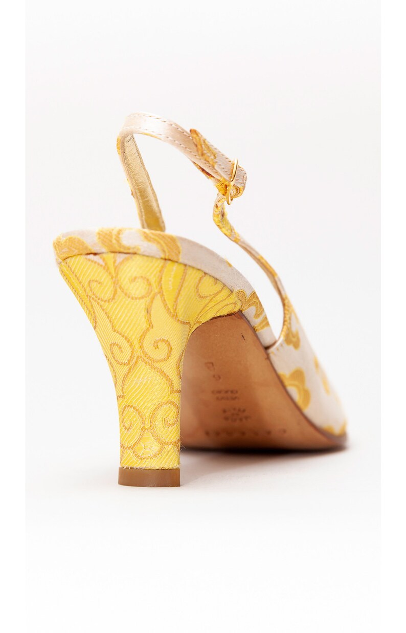 Puede incluir: Tacones amarillos y blancos con tira en el tobillo y un patr&oacute;n floral en el tac&oacute;n. El tac&oacute;n mide aproximadamente 7,5 cm de alto.
