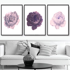 Puede incluir: Tres impresiones enmarcadas de flores moradas y rosas sobre un fondo blanco. Las flores son estilizadas y tienen un aspecto vintage.