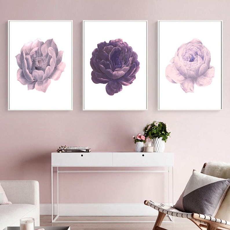 Puede incluir: Tres impresiones florales enmarcadas con fondo blanco. Las impresiones presentan tres flores diferentes de color morado y rosa.