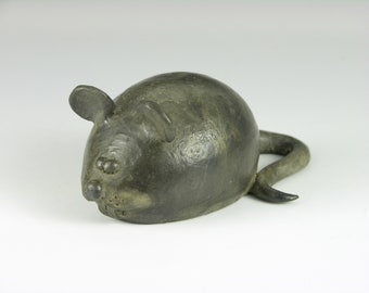 May include: A small, gray ceramic mouse figurine with a curled tail. The mouse has a detailed face with black eyes and a small nose.