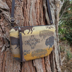 Puede incluir: Una taza de cerámica blanca con un asa negra y el texto "But First, Coffee" en negrita negra. La taza se encuentra sobre un fondo neutro, resaltando su diseño sencillo.