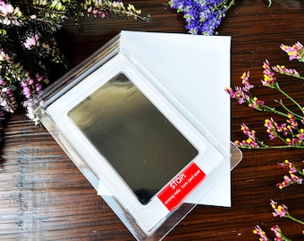 May include: A white plastic frame with a black ink pad inside. The frame has a red label that says "STOP! wrong side, turn card over".