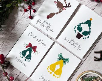 May include: Four Christmas-themed cards with handprint designs. The cards feature a reindeer, a Christmas tree, a bell, and a pair of jingle bells. The text on the cards reads "Rudolph the Red Nose Reindeer", "Picking Around the Christmas Tree", "Christmas Wishes & Mistletoe Kisses", and "Jingle Bells".