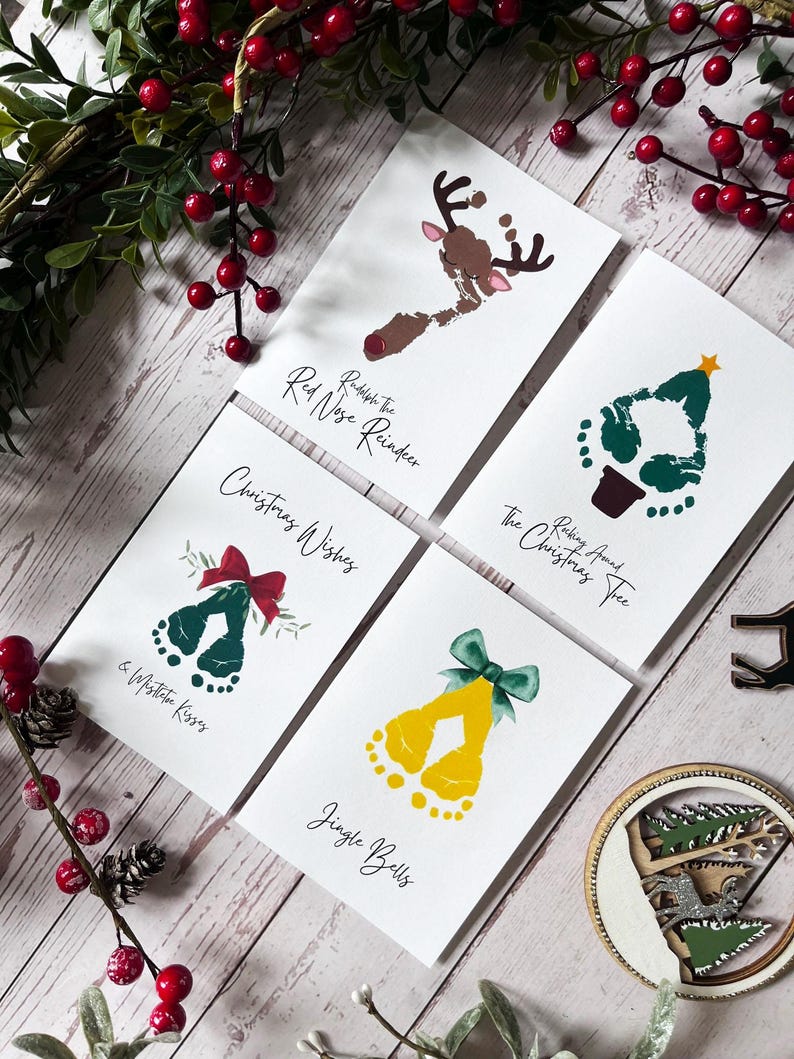 May include: Four Christmas-themed cards with handprint designs. The cards feature a reindeer, a Christmas tree, a bell, and a pair of jingle bells. The text on the cards reads "Rudolph the Red Nose Reindeer", "Picking Around the Christmas Tree", "Christmas Wishes & Mistletoe Kisses", and "Jingle Bells".