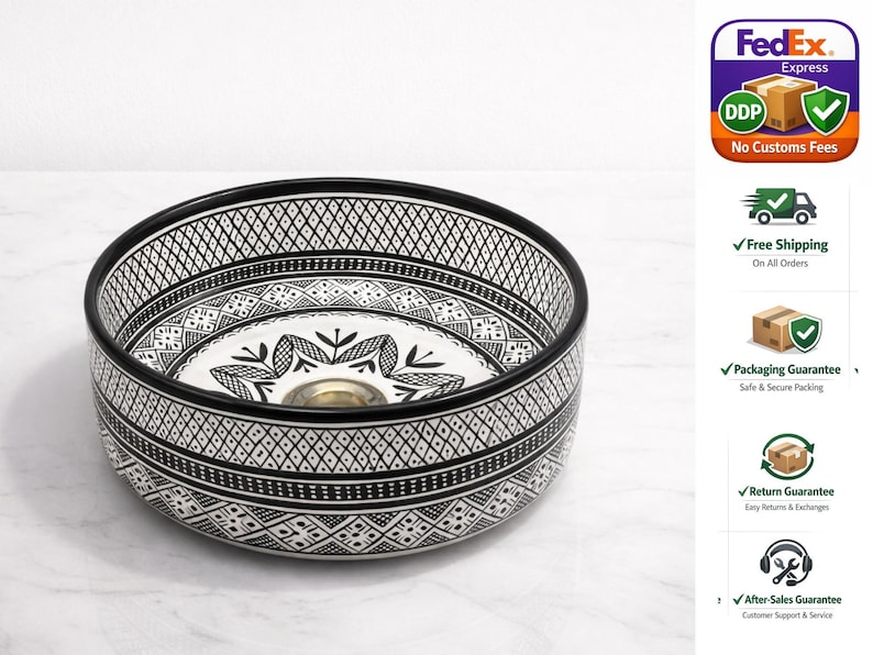 Round Moroccan ceramic vessel sink with hand-painted black-and-white geometric pattern and gold drain on a marble counter.