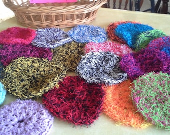 May include: A collection of colorful, crocheted scrubbers in various patterns and colors, including red, blue, green, yellow, and purple. The scrubbers are made with a fluffy, textured yarn and are perfect for cleaning dishes or other surfaces.