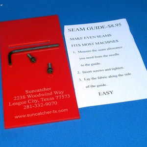 May include: A red plastic sewing guide with screws and a wrench. The guide is labeled "Seam Guide - $8.95" and has instructions for making even seams. The guide is made by Suncatcher and has their contact information on the back.