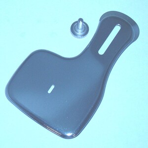 May include: A silver sewing machine foot with a screw attachment. The foot has a long, narrow slot and a small hole.