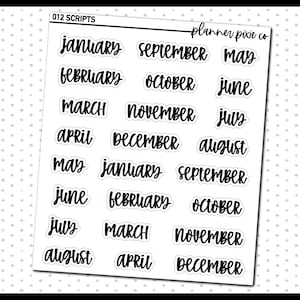 May include: A set of 12 black and white month stickers with a script font. The stickers say "January", "February", "March", "April", "May", "June", "July", "August", "September", "October", "November", and "December".
