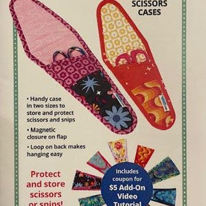 May include: Image of two scissor cases with the text "Cut It Out!". One case is pink with a floral pattern, the other is red with a retro design. The cases are designed to protect and store scissors or snips.