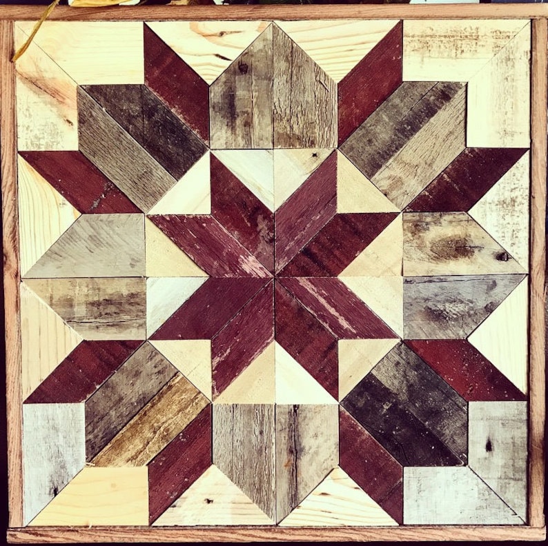 Puede incluir: Una pieza de arte de pared de madera con un patr&oacute;n geom&eacute;trico de madera roja, marr&oacute;n y beige. La madera est&aacute; dispuesta en un patr&oacute;n de estrella.