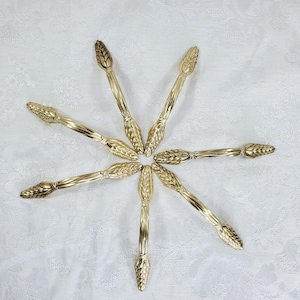 May include: Seven gold-toned cabinet pulls with a wheat design. The pulls are arranged in a starburst pattern.