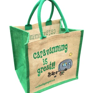 Könnte beinhalten: Eine grüne und braune Jute-Tragetasche mit dem Text "caravanning is great!" und einer Cartoon-Illustration eines Wohnwagens, eines Fahrrads und eines Lagerfeuers. Die Website "www.thebagisgreat.co.uk" ist auf der Unterseite der Tasche aufgedruckt.
