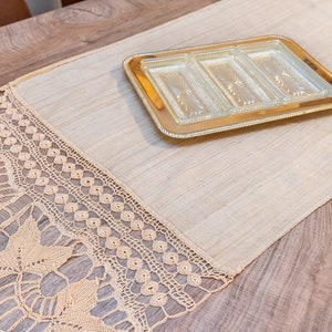 May include: A beige crocheted table runner with a gold-colored tray with four glass compartments on top of it.