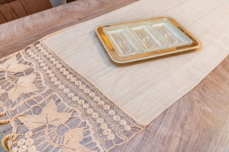 May include: A beige crocheted table runner with a gold-colored tray with four glass compartments on top of it.