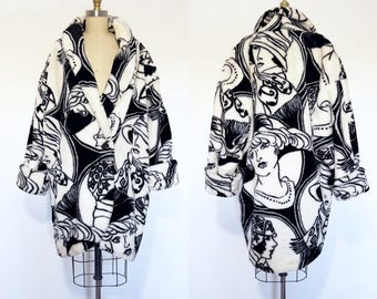 Peut inclure: Un manteau à manches longues avec un imprimé graphique noir et blanc représentant des visages féminins stylisés dans des cadres circulaires. Le manteau possède un large col châle, des manches à revers et une fermeture à un bouton.
