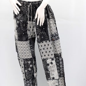 以下が含まれることがあります： 黒と白のパターンが入ったズボンで、ウエストは紐で絞るタイプです。柔らかく快適な生地で作られており、ゆったりとしたフィット感です。