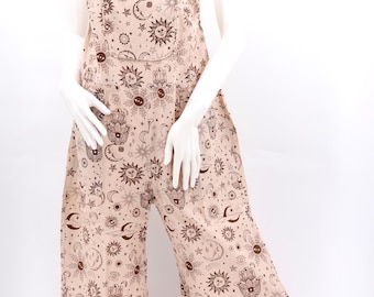 May include: A beige jumpsuit with a brown celestial pattern featuring suns, moons, stars, and Hamsa hand symbols. The wide-leg jumpsuit has adjustable straps and a relaxed fit, perfect for casual wear.