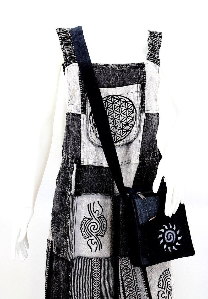 May include: Black and white patchwork denim overalls with a black shoulder strap and a black crossbody bag with a silver sun design.